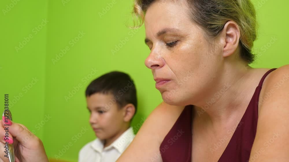 Mother and son are having dinner and drinking while sitting at the table. Mother and son are having dinner and drinking while sitting at the table.