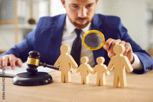 Lawyer inspects wooden family figures using a magnifying glass, symbolizing legal proceedings concerning child custody, family law, divorce, court, justice, and guardianship support.