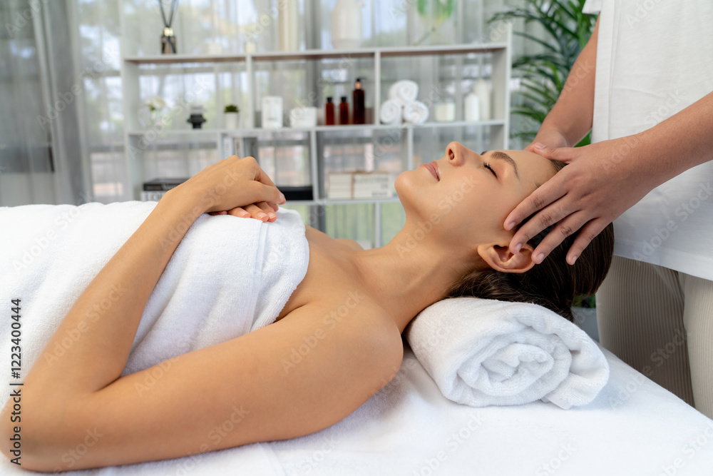 Fototapeta premium Caucasian woman enjoying relaxing anti-stress head massage and pampering facial beauty skin recreation leisure in dayspa modern light ambient at luxury resort or hotel spa salon. Quiescent