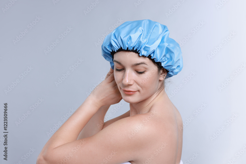 Woman wearing shower cap on grey background Woman wearing shower cap on grey background