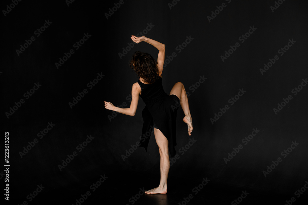 Young slim woman in black outfit with bare feet performing contempo dance moves Young slim woman in black outfit with bare feet performing contempo dance moves