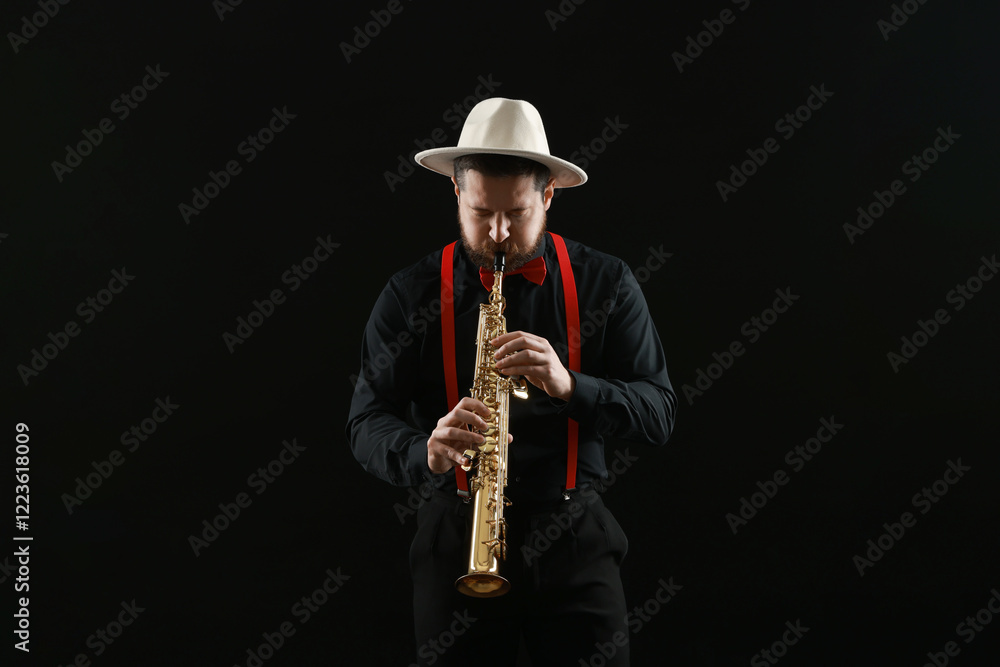 Naklejka premium Professional musician playing soprano saxophone on black background