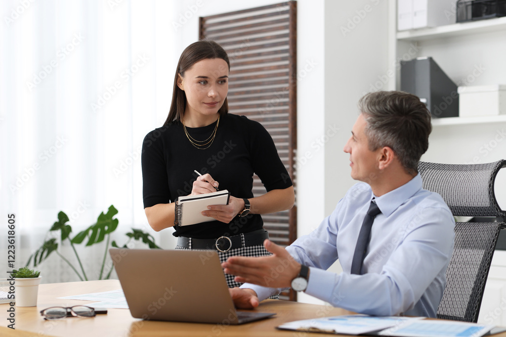 Coworkers working together at table in office Coworkers working together at table in office