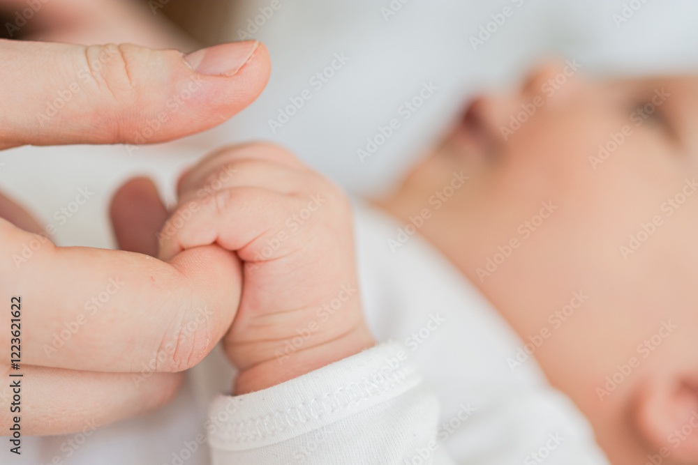 Happy family. Tiny newborn infant baby little hand on mother hand palm. Newborn baby holding parent finger after birth. Mom baby at home. Support protection of new life. Handle with care Happy family. Tiny newborn infant baby little hand on mother hand palm. Newborn baby holding parent finger after birth. Mom baby at home. Support protection of new life. Handle with care