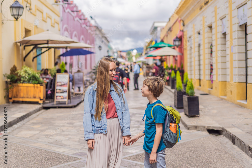 Obraz premium Mother and her son tourists walks through the colonial streets San Cristobal de las Casas, Mexico. Cultural exploration, architecture, and travel experience concept