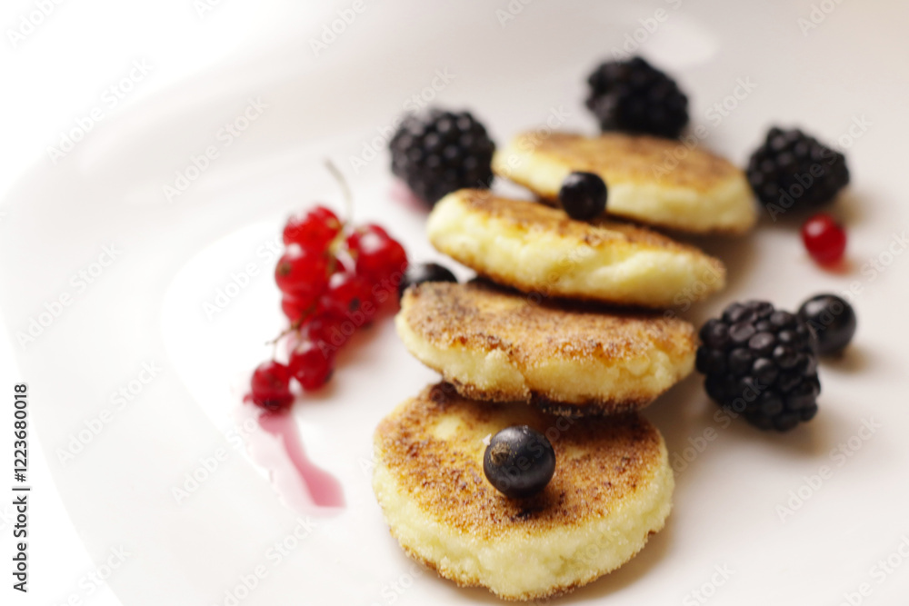 Tasty cheesecakes or pancakes on plate with berries Tasty cheesecakes or pancakes on plate with berries
