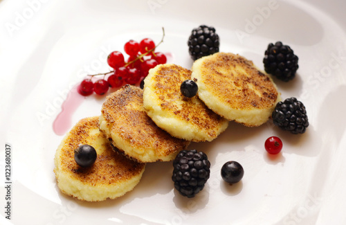 Tasty cheesecakes or pancakes on plate with berries                     