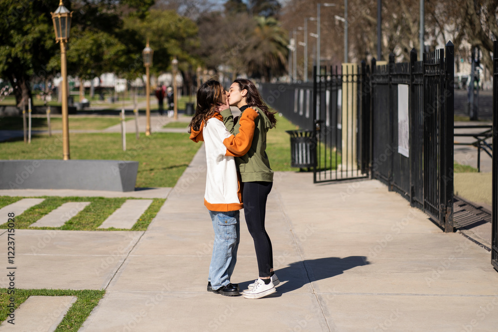 Lesbian couple kissing in a park Lesbian couple kissing in a park