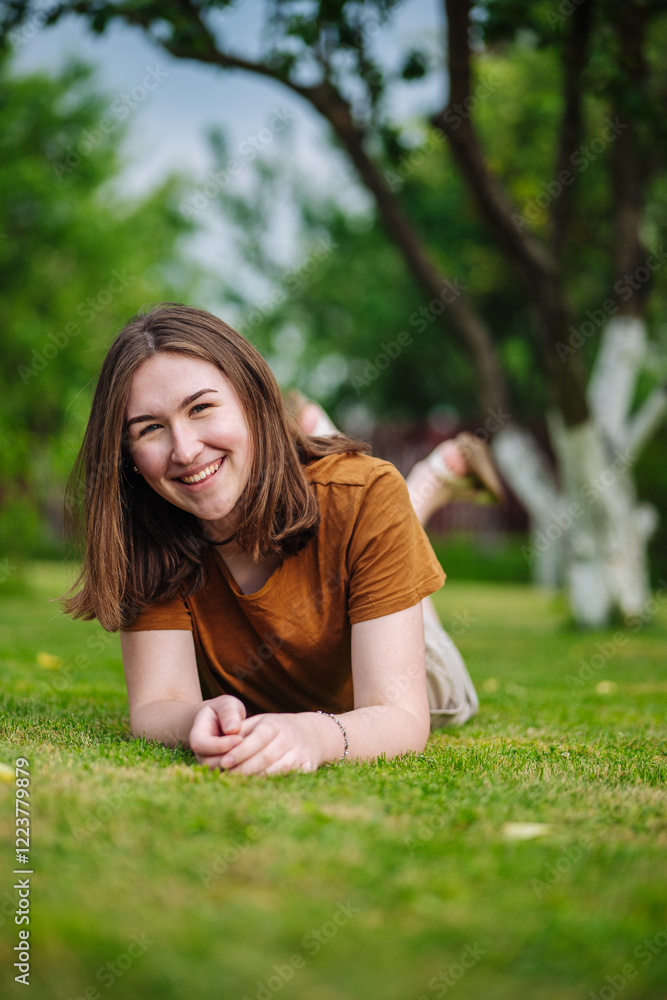 Cheerful woman lying on verdant lawn, basking in golden sunlight and enjoying peaceful summer moment outdoors Cheerful woman lying on verdant lawn, basking in golden sunlight and enjoying peaceful summer moment outdoors