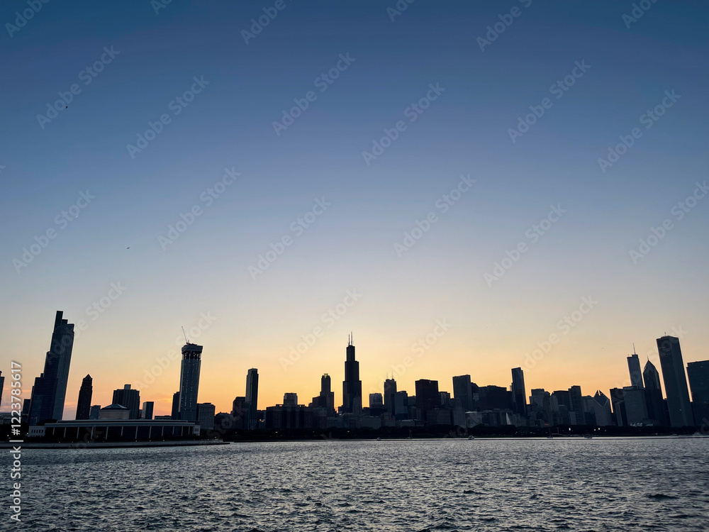 Chicago skyscrapers silhouette reflecting on lake michigan at sunset, creating a beautiful urban landscape Chicago skyscrapers silhouette reflecting on lake michigan at sunset, creating a beautiful urban landscape