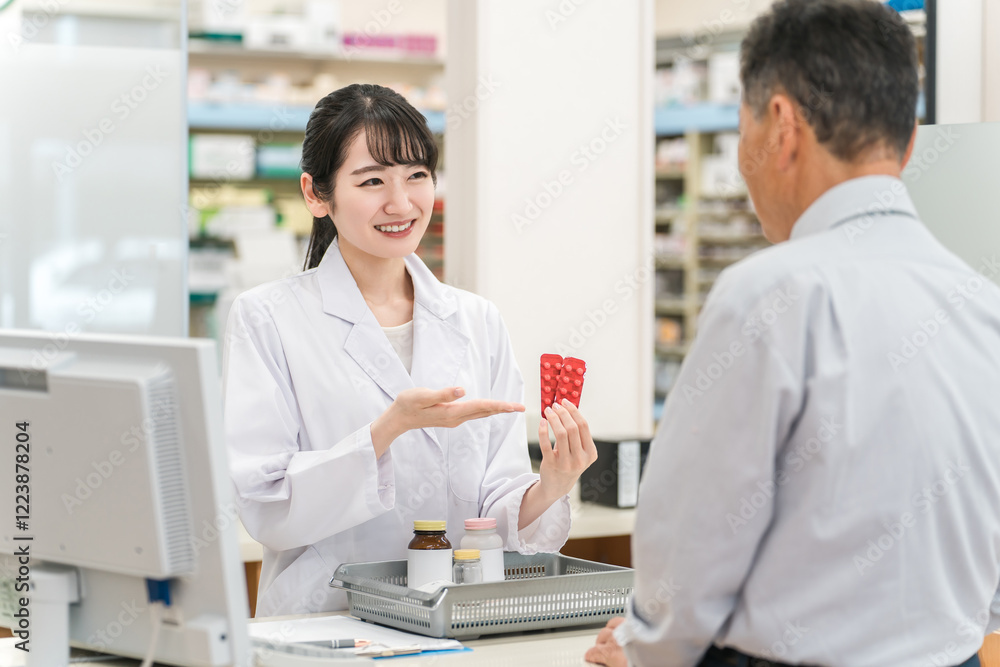 薬局のレジで薬の説明をする薬剤師の女性と高齢者男性
薬局のレジで薬の説明をする薬剤師の女性と高齢者男性
