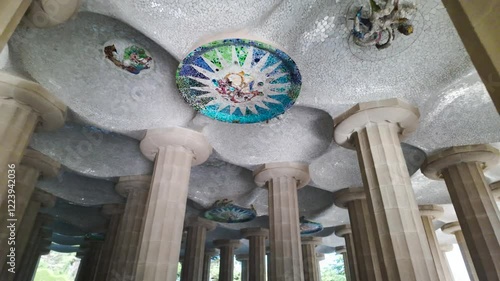 Close up view of the Hypostyle Room in Park Güell, featuring intricate columns and mosaic ceiling art, upward interior angle