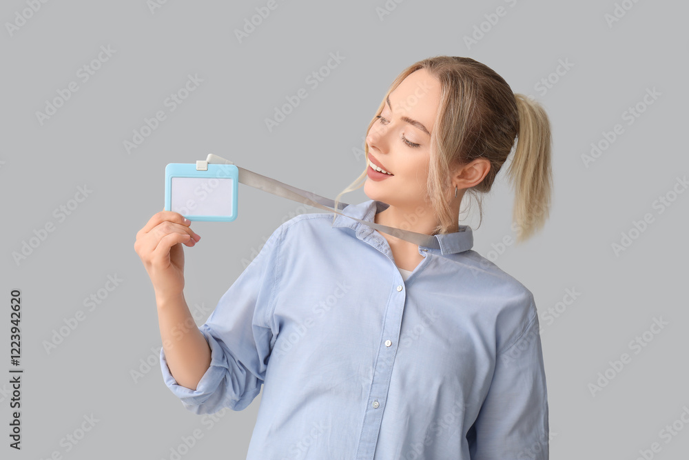 Young woman with blank badge on grey background Young woman with blank badge on grey background