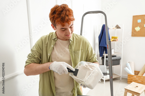 Young man with putty knife ...