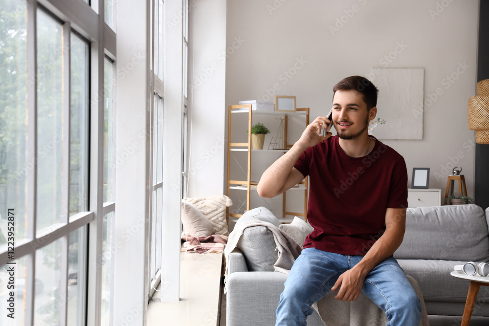 Young man talking by mobile phone on his day off at home Young man talking by mobile phone on his day off at home