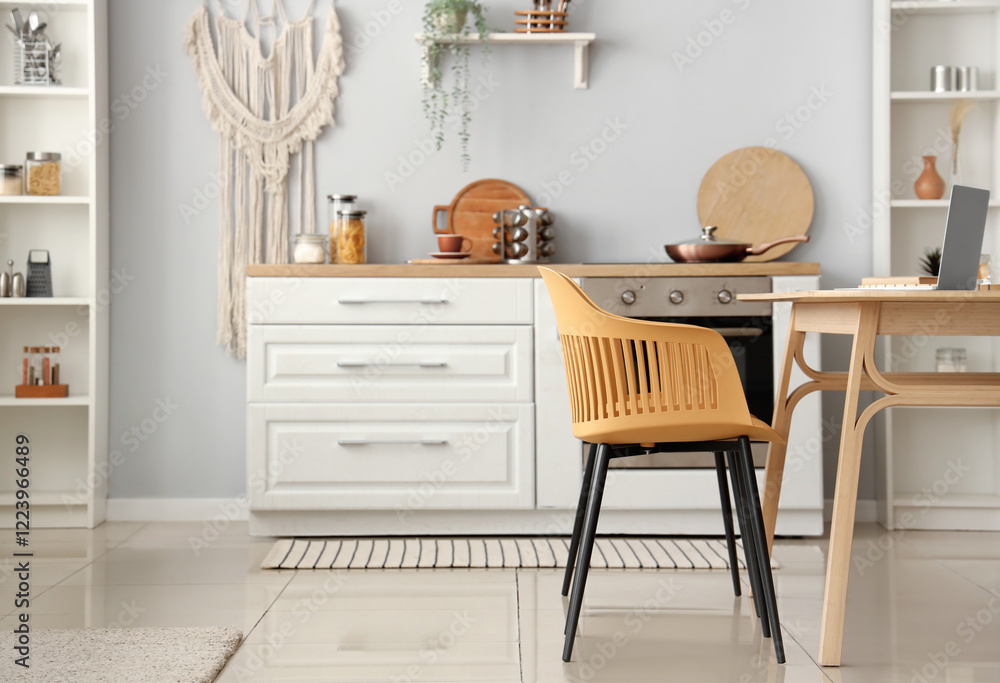Fototapeta premium Interior of light kitchen with white counters and dining table