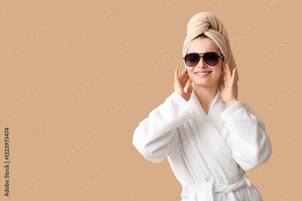 Fototapeta premium Beautiful woman in sunglasses after shower on beige background