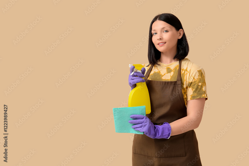 Young woman with rag and spray bottle on beige background Young woman with rag and spray bottle on beige background