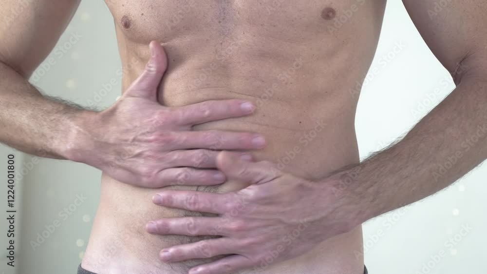 close-up shot of a muscular man having stomach cramps and pains