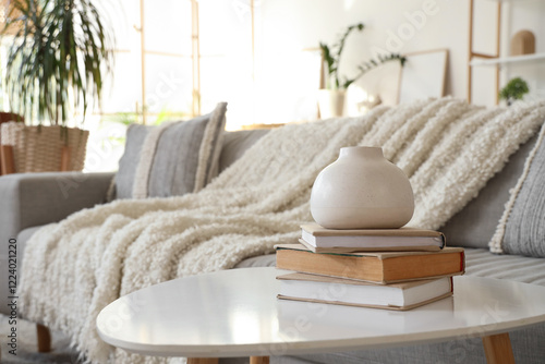 Vase with books on table in...