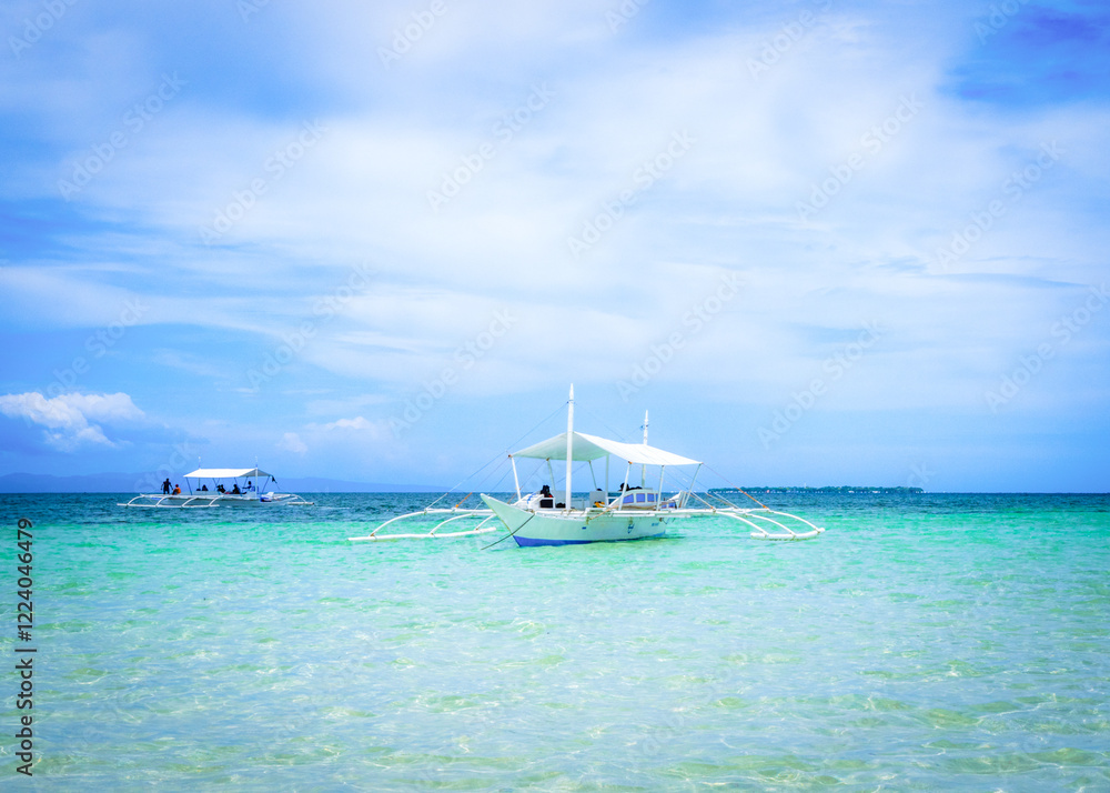 Fototapeta premium A scenic view of Virgin Island in Bohol, Philippines, with two traditional Filipino boats anchored in the crystal-clear water