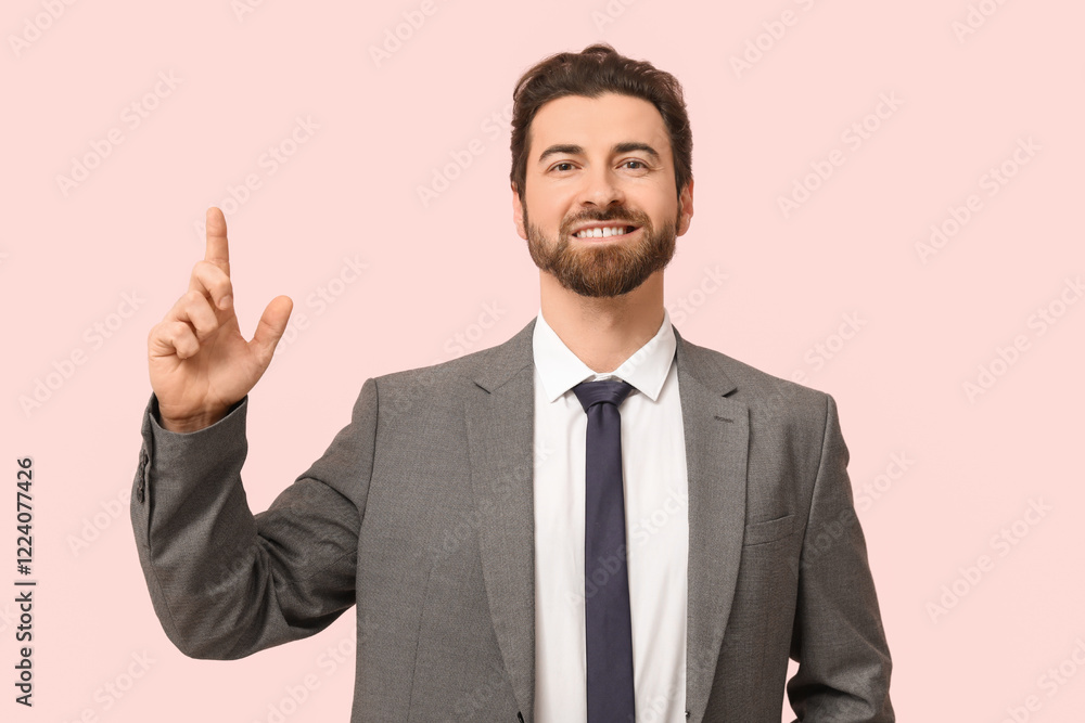 Young businessman pointing up on pink background Young businessman pointing up on pink background