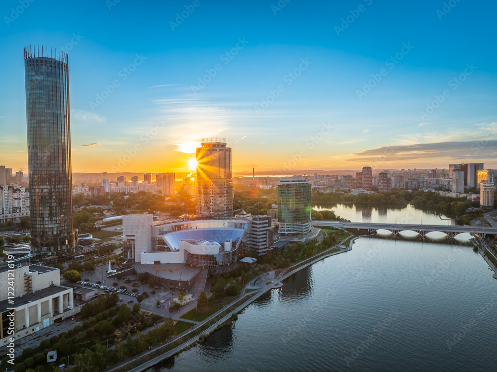 Fototapeta premium Yekaterinburg city and pond aerial panoramic view at summer or early autumn sunset. Night city in the early autumn or summer.
