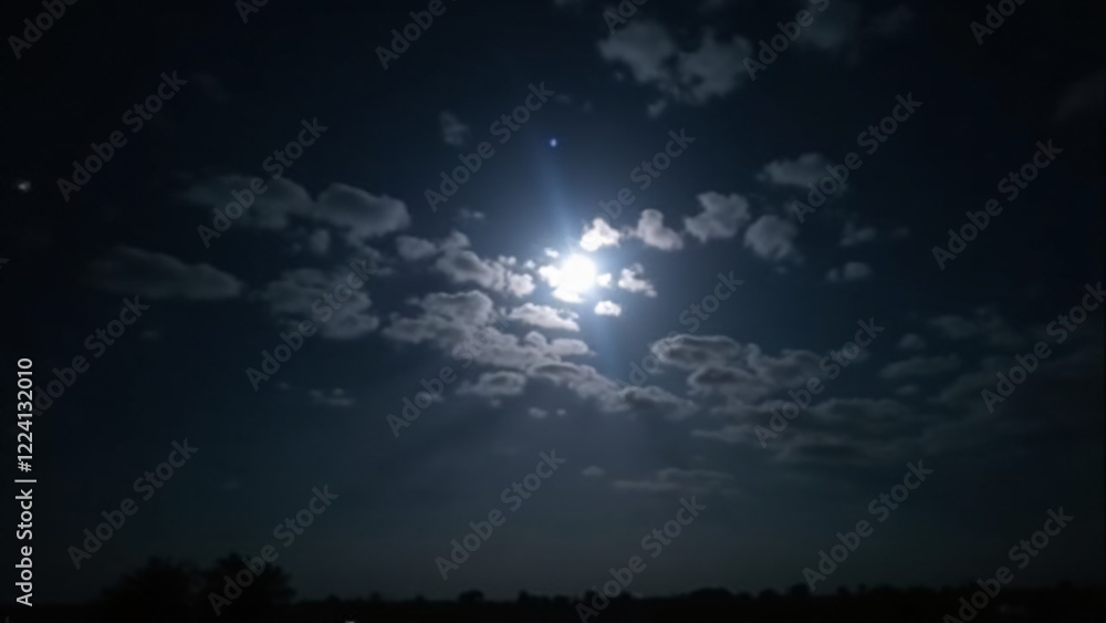 A brilliant full moon shining brightly amidst scattered clouds, casting a serene light over the landscape below. A brilliant full moon shining brightly amidst scattered clouds, casting a serene light over the landscape below.
