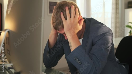 The nervous manager struggles to convey information to the subordinate during a video conference on computer. Frustrated and desperate, he grabs his head with his hands, unable to explain his point.