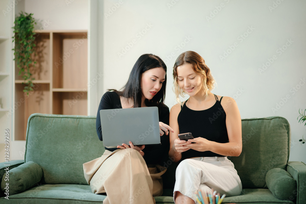 Two women collaborating on a project at home, brainstorming with a laptop and notebook in a cozy setting. Two women collaborating on a project at home, brainstorming with a laptop and notebook in a cozy setting.