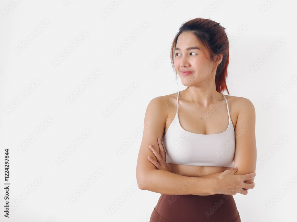 Asian Thai woman wear white sport bras, arms crossed or folding, confidence smiling while standing isolated over white background wall. Asian Thai woman wear white sport bras, arms crossed or folding, confidence smiling while standing isolated over white background wall.