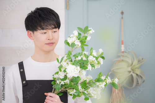 Fotografie Young 20-something male working part-time or part time in a florist shop Image o