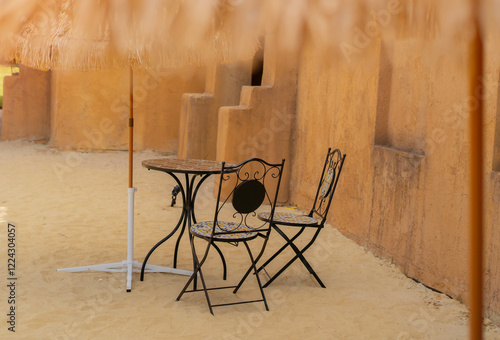 Garden chiars setting on surrounded by sand in an Arabic style cafe photo