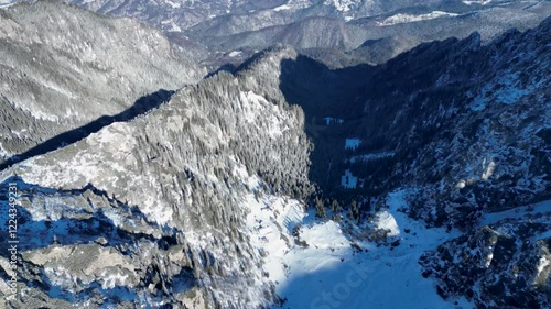 Aerial view of the snowy Malaiesti valley Bucegi Mountains in central Romania, on a sunny day photo