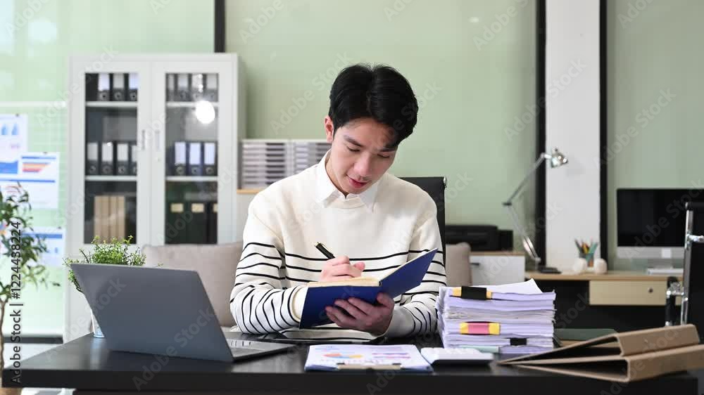 Young Businessman using laptop and tablet while sitting at her working place