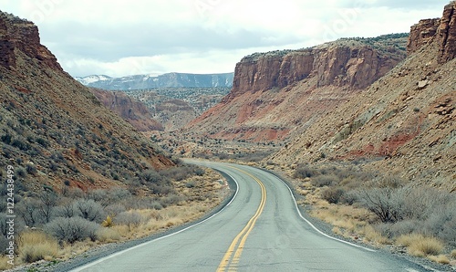 Winding desert road through red rock canyon, distant mountains, for travel or adventure themes