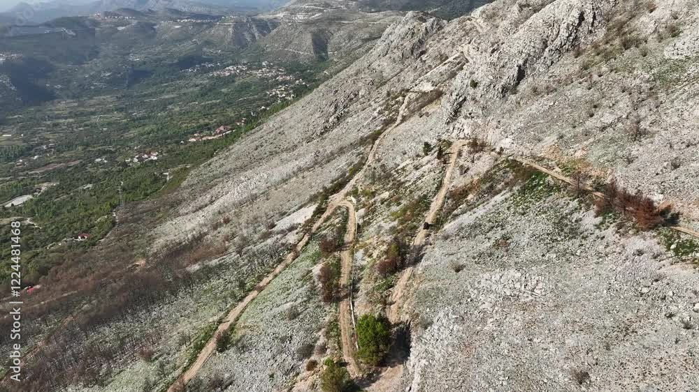 Aerial view of a 4x4 car descending a mountain over a dirt road. Aerial view of a 4x4 car descending a mountain over a dirt road.