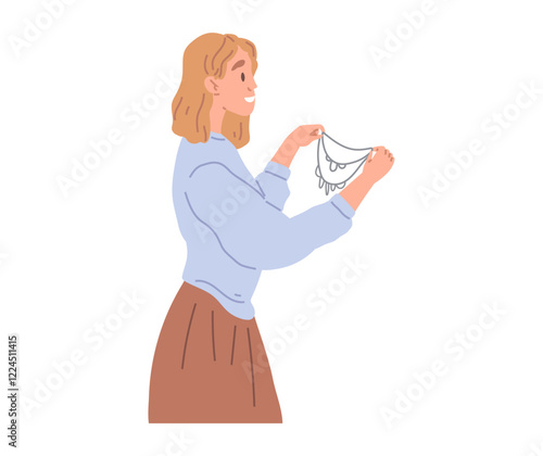 Woman chooses beautiful necklace in womens clothing store. Person stands holds bijouterie in hands in jewelry store. Fashion designer, dressmaker during work. Lady looks at womens wardrobe accessory