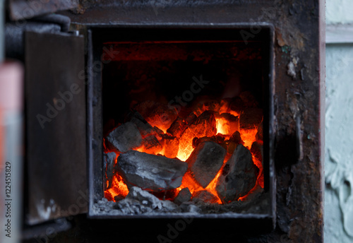 Fire in the fireplace. Fire burning in the stove, a rustic photograph, coziness in a private house, an evening shot.