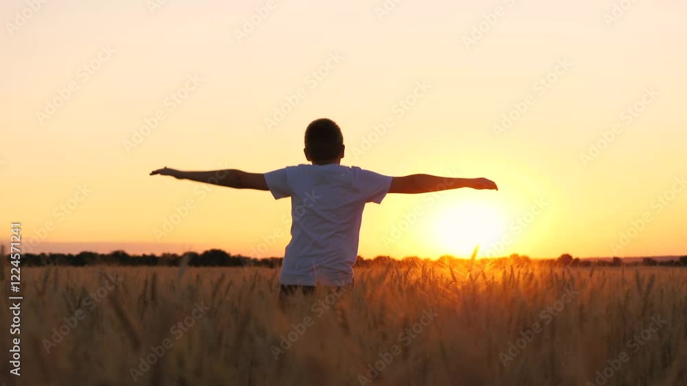 Overjoyed male teenager speed running on wheat field picturesque sunset sunrise bright sun light sky back view. Teen boy movement with raised hands enjoy freedom happy childhood at countryside meadow Overjoyed male teenager speed running on wheat field picturesque sunset sunrise bright sun light sky back view. Teen boy movement with raised hands enjoy freedom happy childhood at countryside meadow