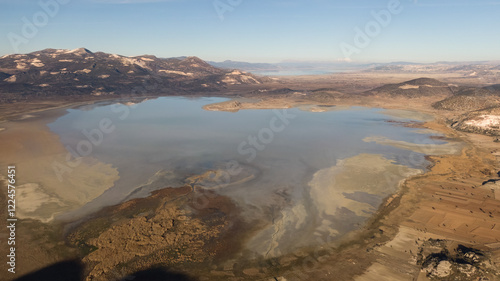 Aerial view of lake water and cracking soils due to drought. Mountain landscape destroyed by marble quarries Lake Yarışlı, Turkey. photo