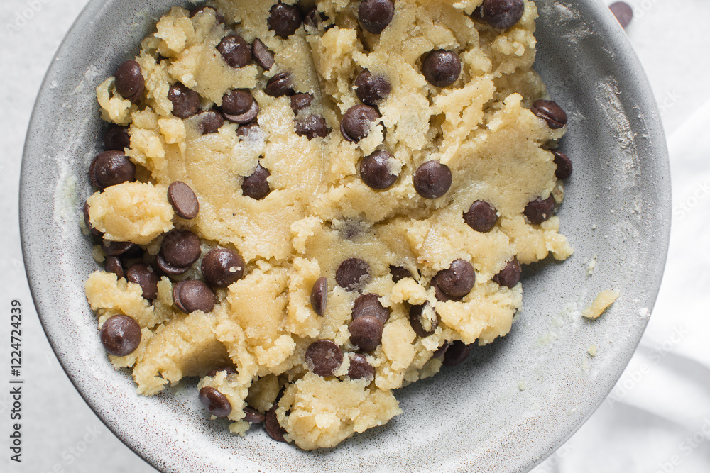 Overhead view of chocolate chip cookie dough, top view of homemade chocolate chip cookie dough in a bowl on a white background, process of making chocolate chip cookies Overhead view of chocolate chip cookie dough, top view of homemade chocolate chip cookie dough in a bowl on a white background, process of making chocolate chip cookies