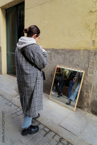 Obraz na płótnie Woman using smartphone next to mirror at el rastro flea market in madrid w salonie