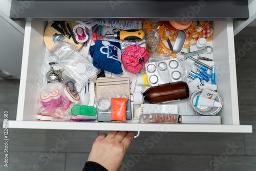 Bild auf Leinwand hand opening a drawer full of various objects piled up in a pile