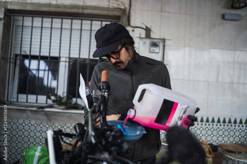 Hombre moreno con gafas poniendo a punto moto de cross para usar en el campo