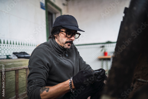 Obraz na płótnie Hombre moreno con gafas poniendo a punto moto de cross para usar en el campo w salonie