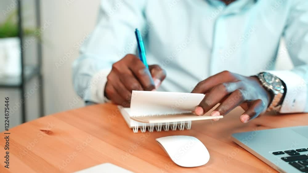 Man write notes in notepad in workplace. Man write notes in notepad in workplace.