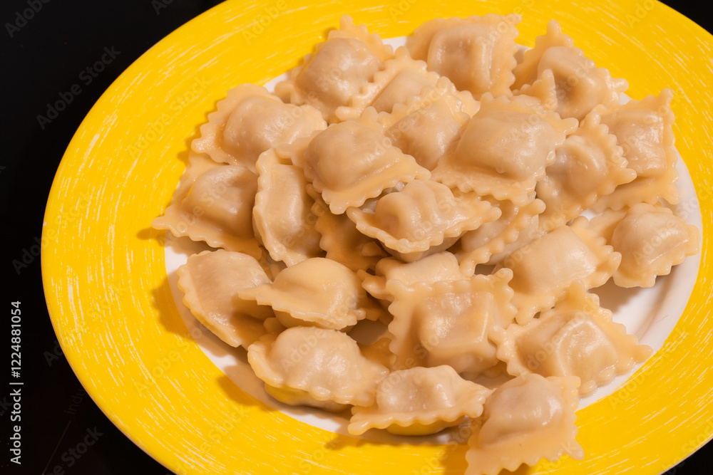 Homemade dumplings on a white plate with a yellow rim. Homemade dumplings on a white plate with a yellow rim.