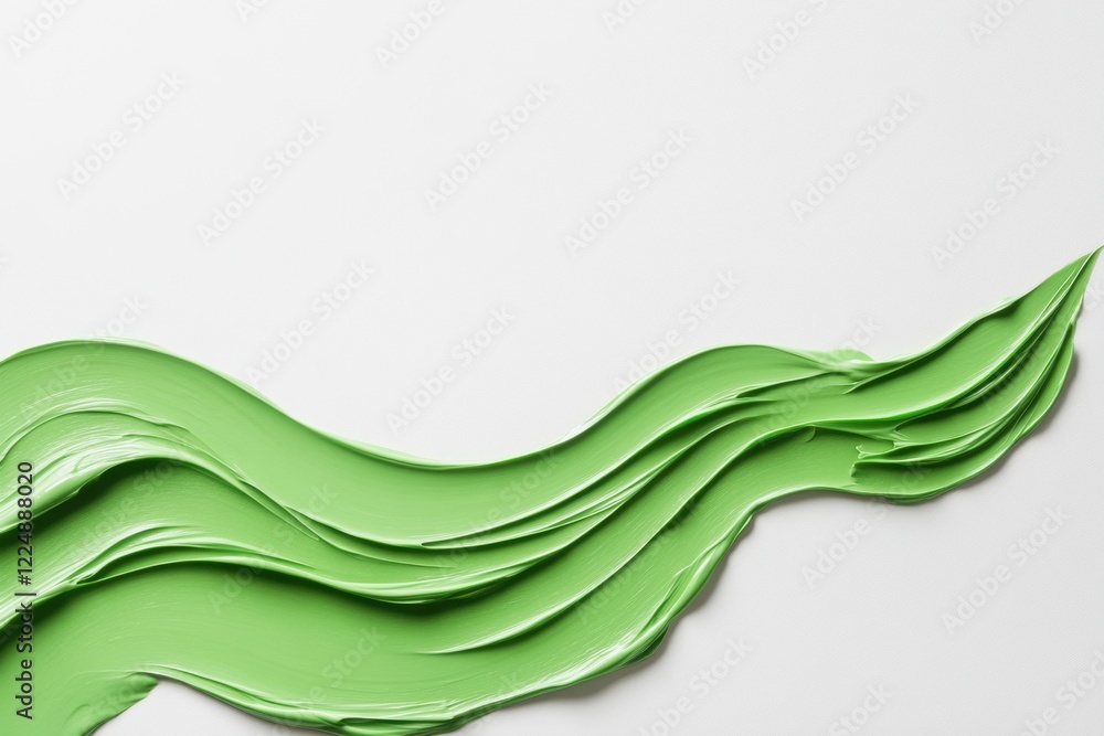 Fototapeta premium Green paste forming a wavy pattern on a white background, evoking nature and freshness