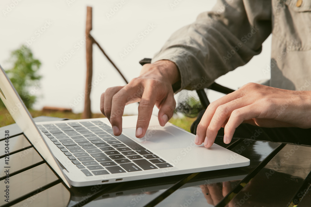 © doidam10 - Young business man working computer on peak hill. Hiker online shopping on laptop at sunset, sunrise on top mountain, freelance person remote work with digital tablet. travel vacation holiday concept